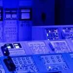Sala de controle moderna com múltiplas telas exibindo dados e painéis de monitoramento em tempo real